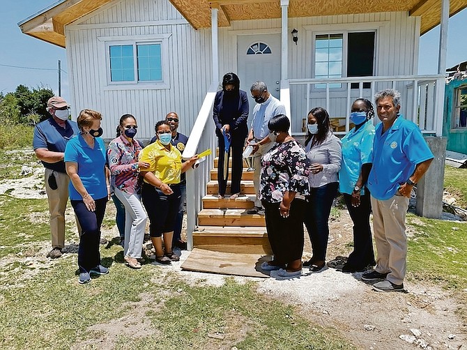 MINISTER of State for Disaster Preparedness, Management and Reconstruction in the Office of the Prime Minister Pakesia Parker-Edgecombe cuts the ribbon to a newly-built home on Sweeting’s Cay on
Friday. From left are, second from left, Lisabeth Knowles, former area governor of Rotary 6990 for Grand Bahama, Diane Pindling, of TK Foundation; Billy Jane Ferguson, area district governor of Rotary
District 8990 for Grand Bahama; homeowners, and far right is James Sarles, chairman of Rotary Disaster Relief Committee. Photo courtesy of Rotary