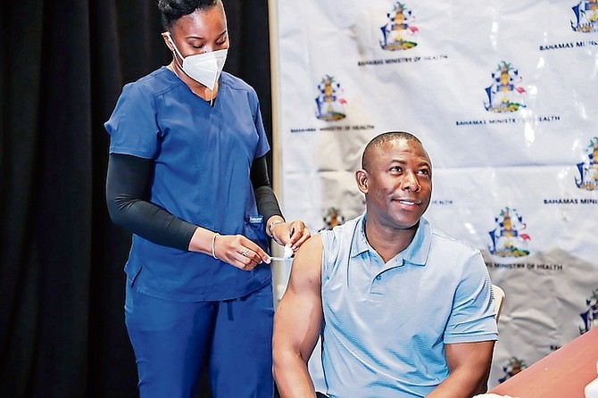 MINISTER of Health Renward Wells receives his second shot of vaccine at the Baha Mar Convention
Centre yesterday, administered by nurse Sharmon Frazer Calendar. Photo: Racardo Thomas