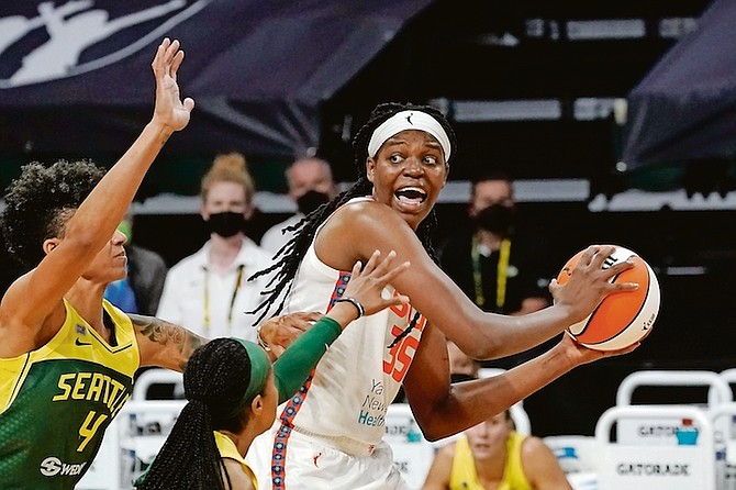Connecticut Sun’s Jonquel Jones, right, looks for room to pass against the Seattle Storm during the first half on May 25 in Everett, Wash. 
 (AP Photo/Elaine Thompson)