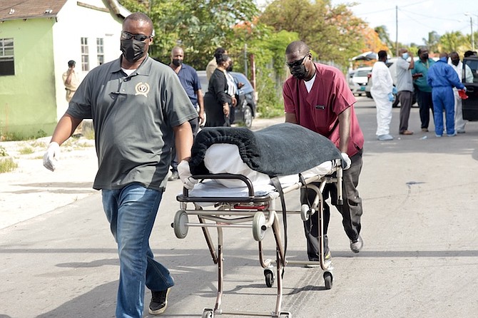A BODY is taken from the scene of the shooting yesterday. Photos: Donovan McIntosh/Tribune Staff