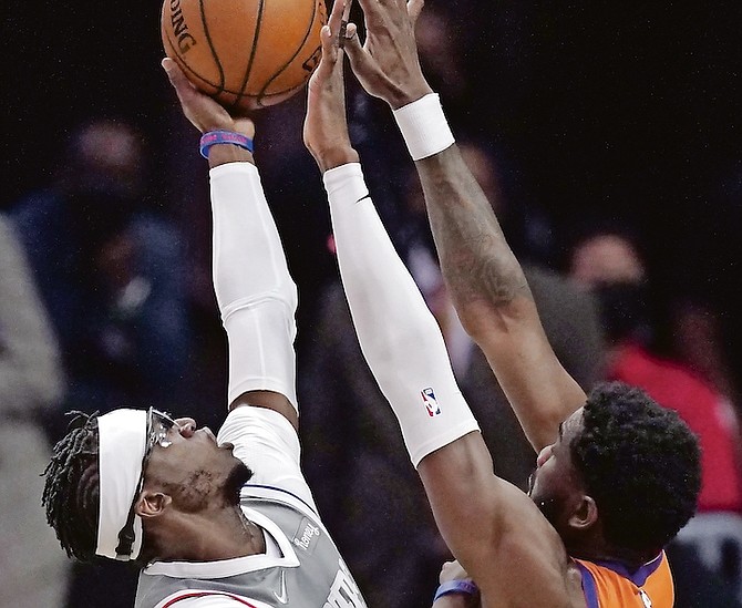 Clippers guard Reggie Jackson, left, shoots as Suns centre Deandre Ayton defends during Game 4 of the NBA Western Conference Finals on Saturday in Los Angeles. (AP Photo/Mark J Terrill)