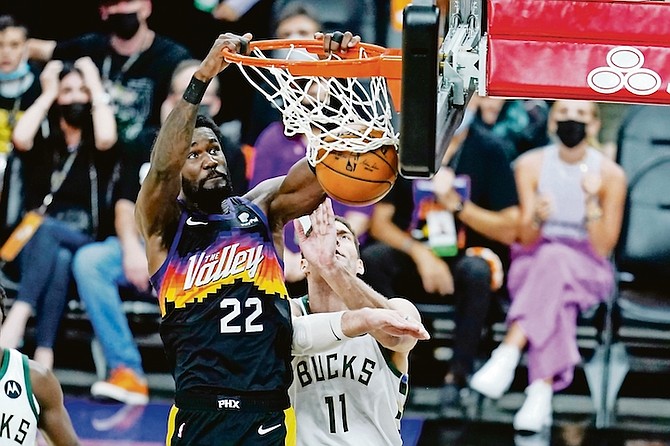 Phoenix Suns centre Deandre Ayton (22) dunks against Milwaukee Bucks center Brook Lopez (11) during the second half of Game 1 of basketball’s NBA Finals, Tuesday, July 6, 2021, in Phoenix. (AP Photo/Ross D. Franklin)
