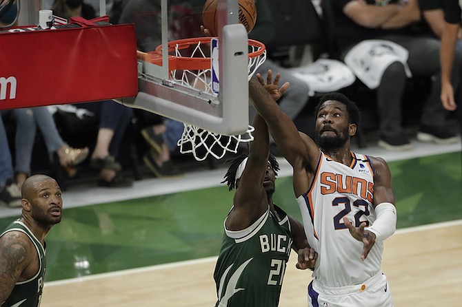Phoenix Suns' Deandre Ayton (22) shoots against Milwaukee Bucks' Jrue Holiday (21) during the first half of Game 3 of basketball's NBA Finals, Sunday, July 11, 2021, in Milwaukee. (AP Photo/Aaron Gash)