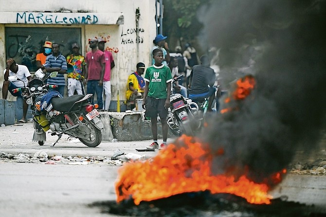 A tyre on fire outside the courthouse in Port-au-Prince yesterday.