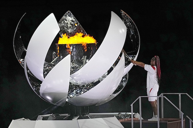Naomi Osaka lights the Olympic flame during the opening ceremony in the Olympic Stadium at the 2020 Summer Olympics, Friday, in Tokyo, Japan. (AP Photo/David J. Phillip)