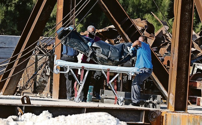 A body is taken from the scene at City Services Ltd yesterday after three men died. 
Photo: Vandyke Hepburn