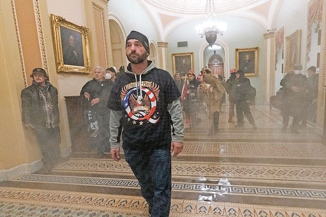 Smoke fills the walkway outside the Senate Chamber as supporters of President Donald Trump are confronted by US Capitol Police officers inside the Capitol on January 6 in Washington. 
Photo: Manuel Balce Ceneta/AP
