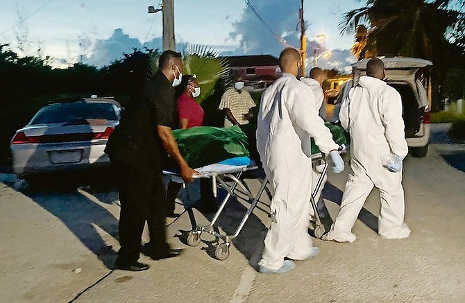 A BODY is taken from the scene last night. Scene photos: Donovan McIntosh/Tribune Staff
