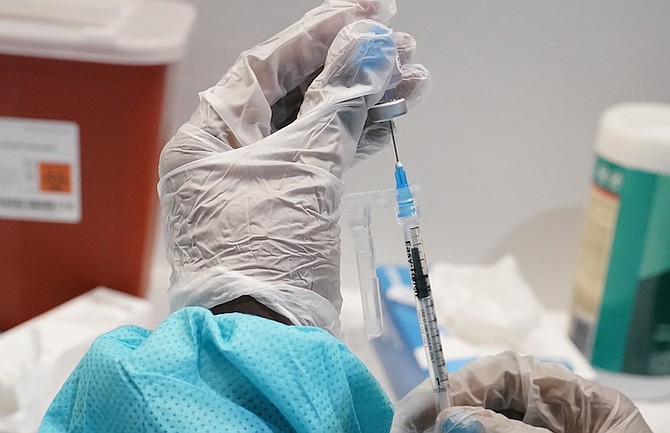 A health care worker fills a syringe with the Pfizer COVID-19 vaccine in the US last year. (AP Photo/Mary Altaffer, File)