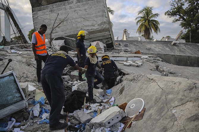 Firefighters search for survivors inside a collapsed building, after Saturday´s 7.2 magnitude earthquake in Les Cayes, Haiti, Sunday, Aug. 15, 2021. (AP Photo/Joseph Odelyn)