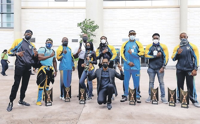 MEDAL HAUL: The Bahamas Bodybuilders and Fitness Federation’s eight-member team returned yesterday from the Central American and Caribbean Bodybuilding Championships in San Salvador, El Salvador, over the weekend. The team, managed by Nardo Dean, captured two gold, three silver and three bronze medals. Some of the team members can be seen at Lynden Pindling International Airport yesterday. 
Photo by Donavan McIntosh