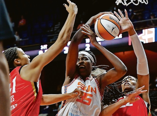 Connecticut Sun’s Jonquel Jones (35) fights to keep control of the ball against Las Vegas Aces’ Kiah Stokes (41) and A’ja Wilson (22) during a WNBA basketball game on Tuesday in Uncasville, Connecticut.

(Dana Jensen/The Day via AP)