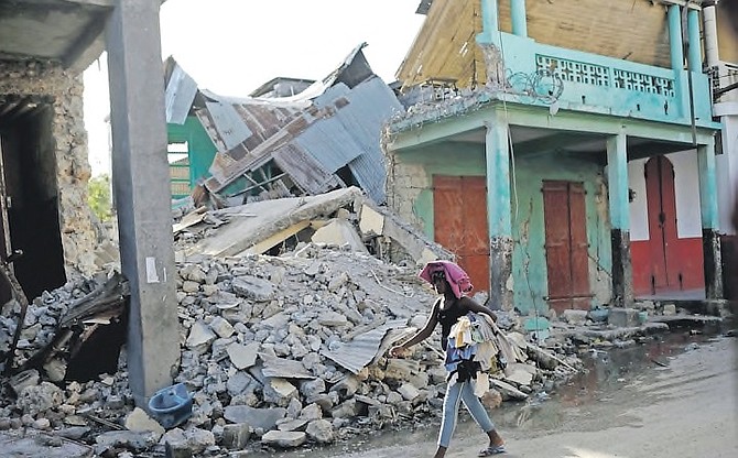 A WOMAN walks past a collapsed building in Jeremie, Haiti, after the 7.2-magnitude earthquake. (AP Photo/Matias Delacroix)