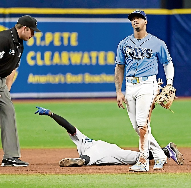 Umpire John Libka, left, looks on as Miami Marlins’ Jasrado “Jazz” Chisolm Jr, centre, gestures after sliding into second base under the tag from Tampa Bay Ray’ Wander Franco, right, during the sixth inning of a baseball game yesterday in St. Petersburg, Fla.

(AP Photo/Steve Nesius)