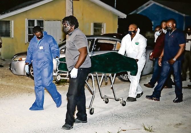 A body is taken from the scene in Apache Alley off Kemp Road last night, after a father was killed and his daughter injured as shots were fired into a car containing both them and their mother. Photo: Racardo Thomas/Tribune Staff