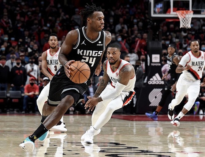 SACRAMENTO Kings guard Buddy Hield, left, runs down the clock as Portland Trail Blazers guard Damian Lillard, right, defends late during the second half in Portland, Oregon, on Wednesday, October 20, 2021. The Kings won 124-121.
(AP Photo/Steve Dykes)