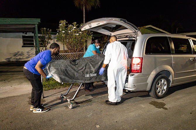 A body is taken from the scene. 
Photo: Racardo Thomas/Tribune Staff