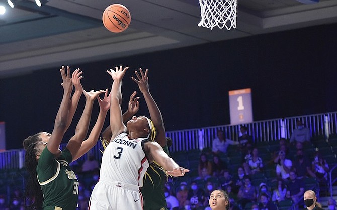 THIS photo provided by Bahamas Visual Services shows UConn forward Aaliyah Edwards (3) battling South Florida for the ball as UConn’s Azzi Fudd (35) looks on during an NCAA college basketball game at Atlanta Paradise Island in Nassau, Bahamas, yesterday. 
(Donald Knowles/Bahamas Visual Services via AP)