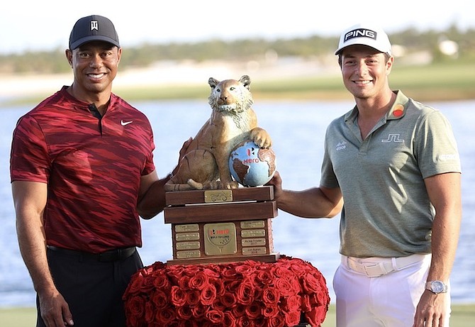VIKTOR HOVLAND, of Norway, right, and Tiger Woods pose with the championship trophy yesterday after the final round of the Hero World Challenge PGA Tour at the Albany Golf Club. 
Photo: Donavan McIntosh/Tribune staff
