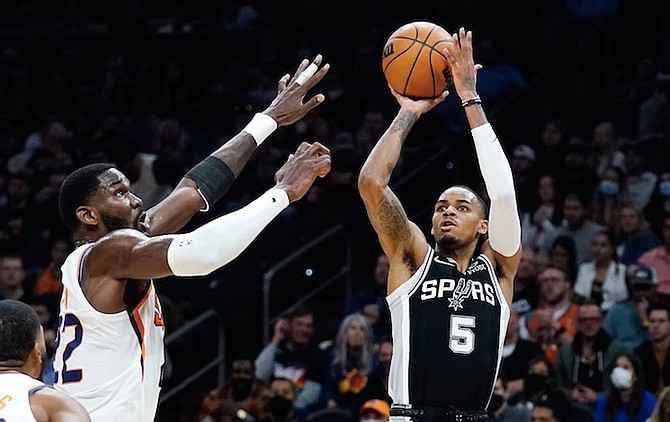 SPURS guard Dejounte Murray (5) shoots over Suns centre Deandre Ayton, left, during the first half last night in Phoenix. Ayton posted 14 points, nine rebounds, four assists and a block but he had five turnovers in 35 minutes. (AP Photo/ Ross D Franklin)