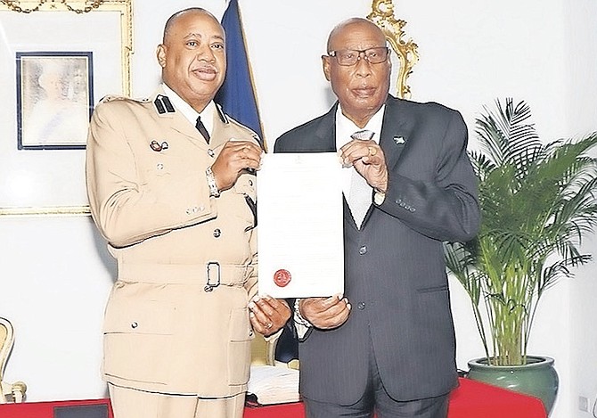 Clayton Fernander being sworn in by Governor General Sir Cornelius A Smith yesterday as Deputy Commissioner of the Royal Bahamas Police Force - more than two years after he and several other senior officers were controversially ordered to take vacation leave and were then given assignments at government ministries they thought were beneath their roles and experience. Photo: BIS