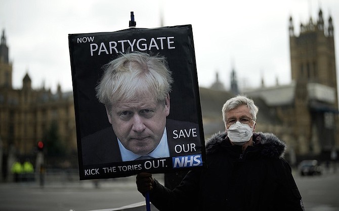 AN ANTI-Conservative Party protester holds a placard with an image of British Prime Minister Boris Johnson including the words “Now Partygate” backdropped by the Houses of Parliament, in London, after recent scandals over reports of parties being held by politicians and staff while the rest of the country was in lockdown. Photo: Matt Dunham/AP