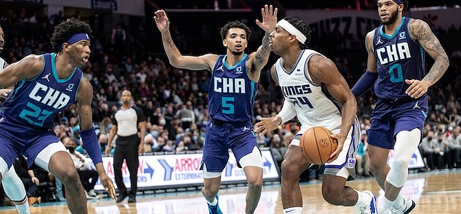 HORNETS forward Kai Jones (23), guard James Bouknight (5), and forward Miles Bridges (0) surround Kings guard Buddy Hield (24) during the second half on December 10 in Charlotte, N.C. (AP Photo/Matt Kelley)