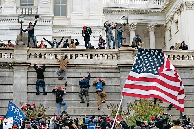 RIOTERS scale a wall at the U.S. Capitol on Jan. 6, 2021, in Washington. (AP Photo/Jose Luis Magana)