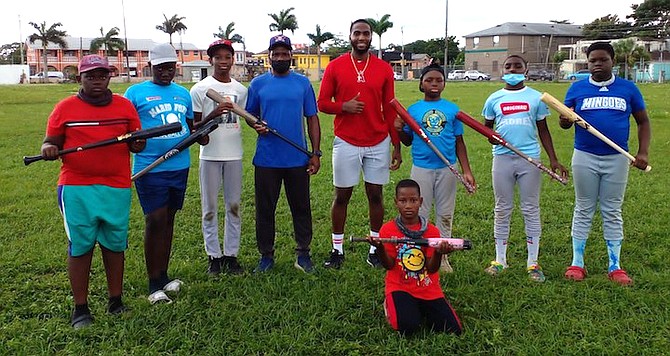 TRENT DEVEAUX, pictured 5th from left, donates bats to the Mario Ford Baseball Camp on Saturday.
