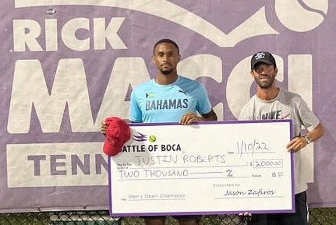 TOP-ranked Bahamian male tennis player Justin Roberts, left, receives his winning pay cheque after winning the Battle of Boca Men’s Open Championships at the Rick Macci Tennis Centre in Boca Raton, Florida.