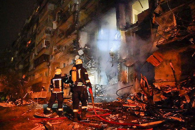 Firefighters inspect the damage at a building following a rocket attack on the city of Kyiv, Ukraine, Friday. (Ukrainian Police Department Press Service via AP)