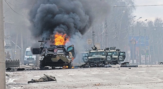 AN ARMORED personnel carrier burns and damaged light utility vehicles stand abandoned after fighting in Kharkiv, Ukraine, yesterday. 
Photo: Marienko Andrew/AP