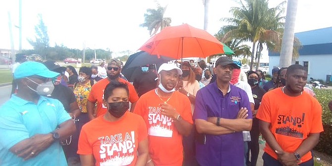 Seen second from left are Sarah and Darren Cooper, along with Rev Frederick McAlpine, up front leading a march to and from the Grand Bahama Port Authority Headquarters Building in Downtown Freeport on Friday. The group delivered a letter to GBPA president Ian Rolle outlining their concerns about the state of Freeport and its economy. Iram Lewis, FNM MP for Central Grand Bahama, seen far left, also marched with the group. Photo by Denise Maycock