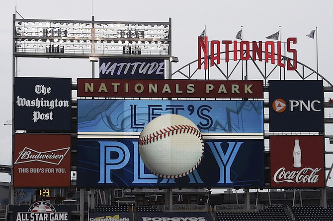 The scoreboard plays the seventh inning stretch themes of the Toronto Blue Jays during the middle of the seventh inning of a baseball game between the Blue Jays and the Washington Nationals, on July 30, 2020, in Washington. Players voted Thursday, March 10, 2022, to accept MLB's offer on new labor deal, paving way to end 99-day lockout and salvage 162-game season. (AP Photo/Nick Wass, File)