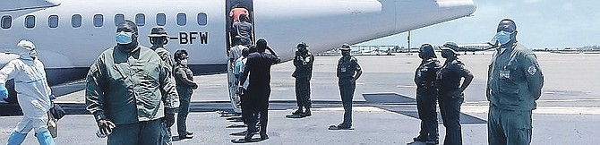 HAITIAN migrants being loaded onto the charter flight yesterday for repatriation.