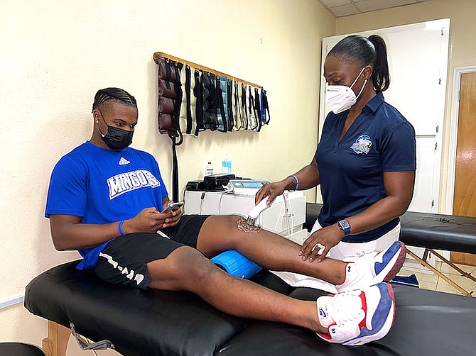 UNIVERSITY of the Bahamas head athletic trainer Sasha Johnson provides treatment to UB men’s basketball guard Theo Grant.
(UB ATHLETICS)