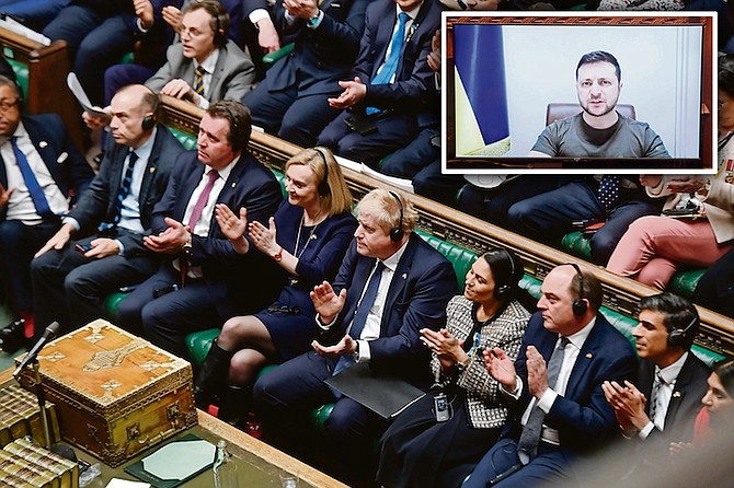 BRITAIN’S Prime Minister Boris Johnson, centre, and lawmakers applaud as Ukrainian President Volodymyr Zelenskyy is displayed on a screen, top right, and addresses the House of Commons in London, last Thursday. Photos: Jessica Taylor/UK Parliament via AP