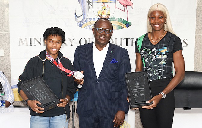 A HERO’S WELCOME: World Athletics Indoor Championship medallists Shaunae Miller-Uibo, (400m gold), far right, and Devynne Charlton (60mH silver), show off their awards with Deputy Prime Minister Chester Cooper, Minister of Tourism, Investments & Aviation.
Photo by Racardo Thomas/Tribune Staff