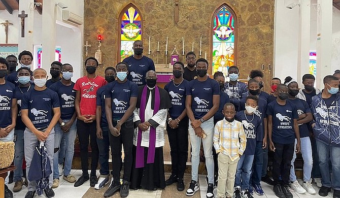 REV Fr Neil G Nairn is flanked by members of Swift Athletics during their church service at Holy Spirit Anglican Church on Sunday.