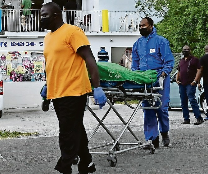 A body is taken from the scene yesterday in Baillou Hill Road. 
Photo: Racardo Thomas/Tribune Staff