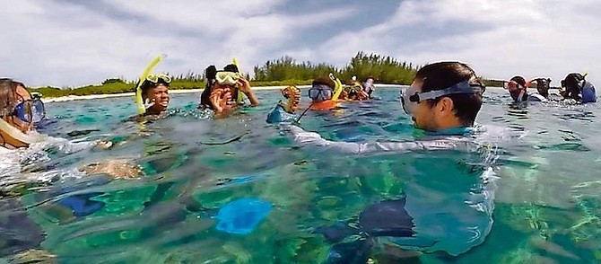 DR. NICK HIGGS giving snorkeling lessons and teaching Bahamian students about the marine environment, and what it is to be a Bahamian marine biologist.