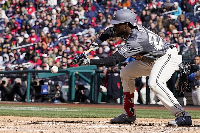 WASHINGTON Nationals’ Lucius Fox bunts the ball to score Dee Strange-Gordon during the eighth inning of a baseball game against the New York Mets at Nationals Park yesterday. The Nationals won 4-2. (Photo: Alex Brandon/AP)