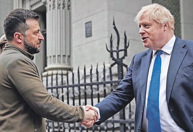 In this image provided by the Ukrainian Presidential Press Office, Ukrainian President Volodymyr Zelenskyy, left, and Britain’s Prime Minister Boris Johnson, shake hands during their walk in downtown Kyiv, Ukraine, on Saturday, April 9.