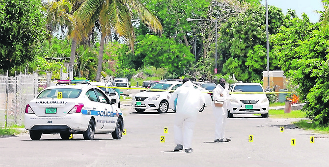 OFFICERS at the scene in Antigua Street yesterday putting down evidence markers, including on a police car reportedly hit by gunfire.
Photos: Donavan McIntosh/Tribune Staff