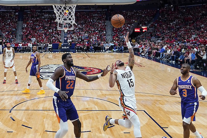 New Orleans Pelicans guard Jose Alvarado (15) goes to the basket between Phoenix Suns centre Deandre Ayton (22) and guard Chris Paul (3) in the second half of Game 6 of an NBA basketball first-round playoff series, Thursday, in New Orleans. The Suns won 115-109, to win the series 4-2 and advance to the second-round. (AP Photo/Gerald Herbert)