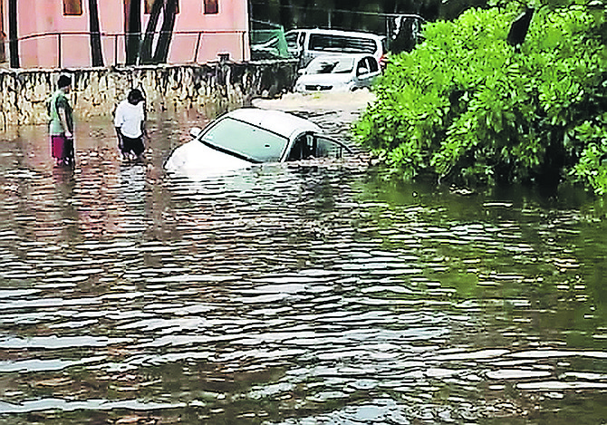 A CAR swallowed up in flood water over the weekend as a record amount of rainfall hit New Providence. Photo: Racardo Thomas/Tribune Staff