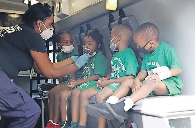 CHILDREN from Willard Patton Pre-School get a close look at equipment inside an ambulance during a visit to the school yesterday. Photos: Racardo Thomas/Tribune Staff