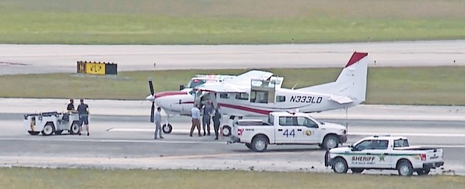 This still image from video by WPTV shows emergency personnel surrounding a Cessna plane at Palm Beach International Airport on Tuesday in West Palm Beach, Florida. A passenger with no flying
experience was able to land the plane safely with help of air traffic controllers after the pilot was too sick to handle the controls.