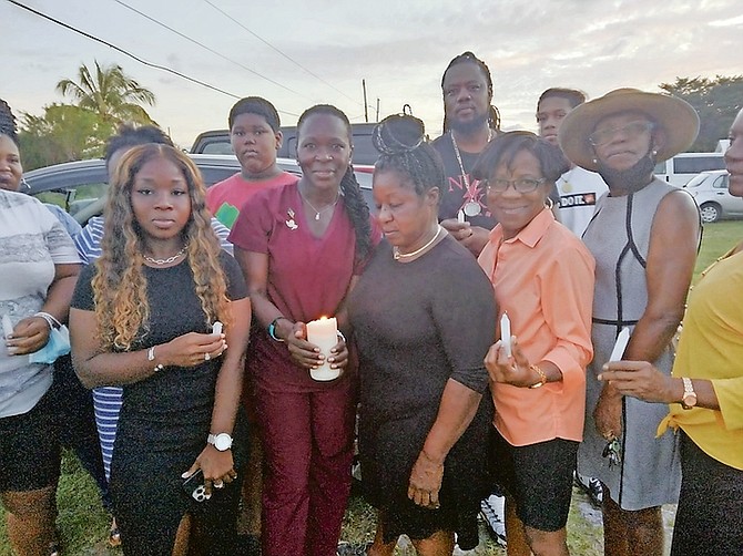SHAVON Munnings (centre in black with candle) held a candlelight vigil on Tuesday in memory of her sister, Tiffany Smith, 30, a mother of four who was murdered 17 years ago by her husband. Ms Munnings, founder of Fallen Angels Candlelight Reach Out, has held the vigil annually for more than a decade to raise awareness of domestic violence. The vigil preceded a three-day Domestic Violence Awareness Conference at First Holiness Church grounds. Photo: Denise Maycock/Tribune Staff