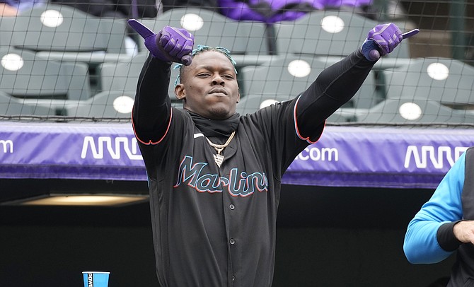 MIAMI Marlins’ Jazz Chisholm Jr gestures to Avisail Garcia after he hit an RBI-single off Colorado Rockies starting pitcher Antonio Senzatela in the fourth inning of the first game of a baseball doubleheader yesterday in Denver. 
(AP Photo/David Zalubowski)